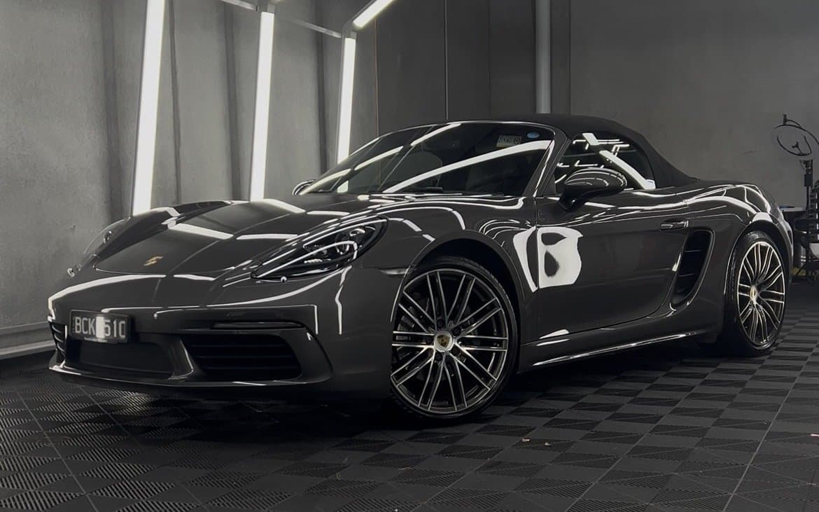 Porsche 718 under inspection lights with a Signature ceramic coating