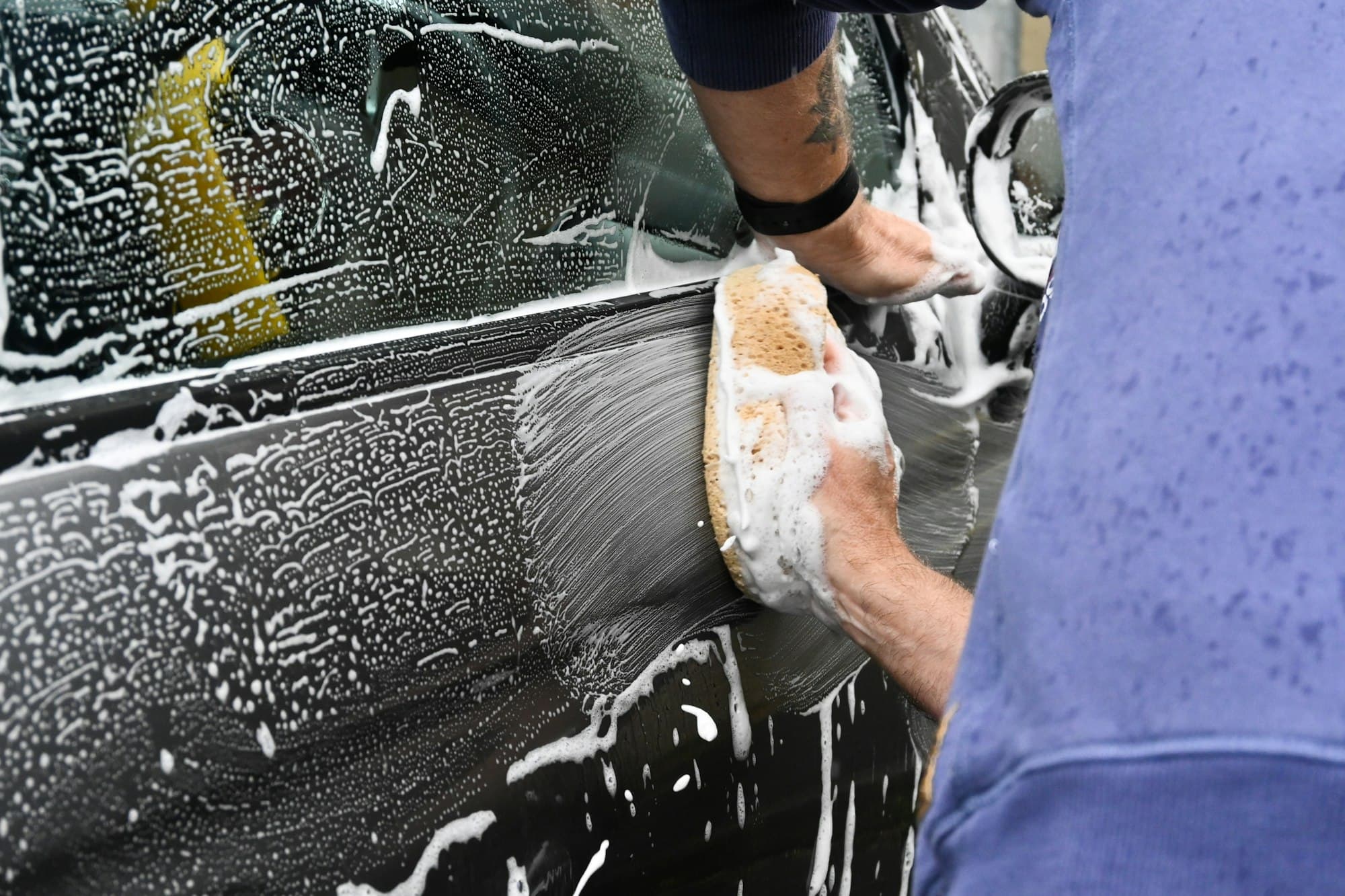 Car being hand washed with a sponge