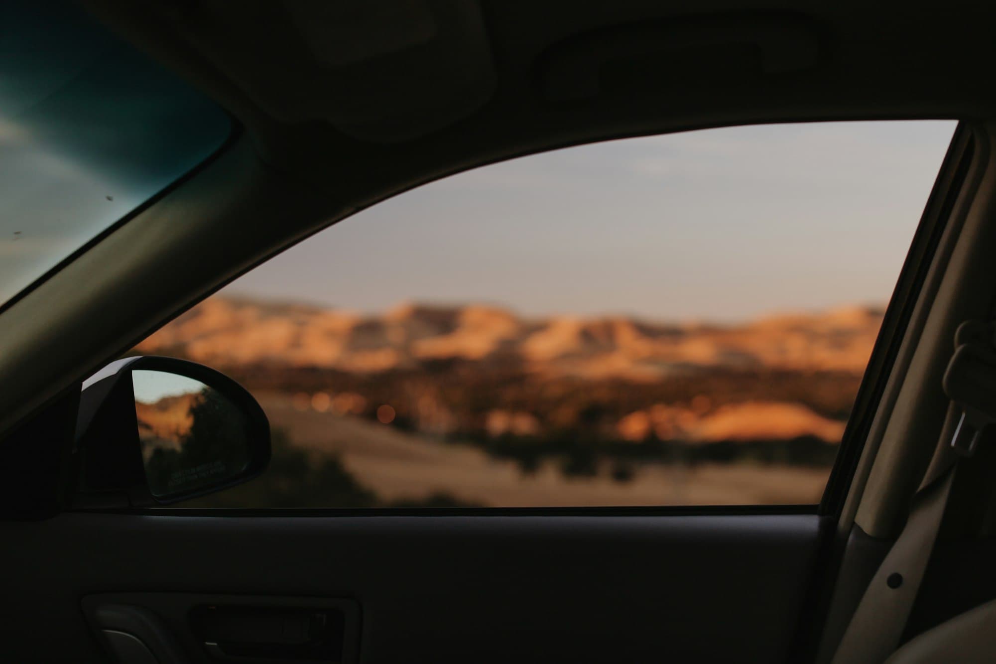 View through a car side window at sunset