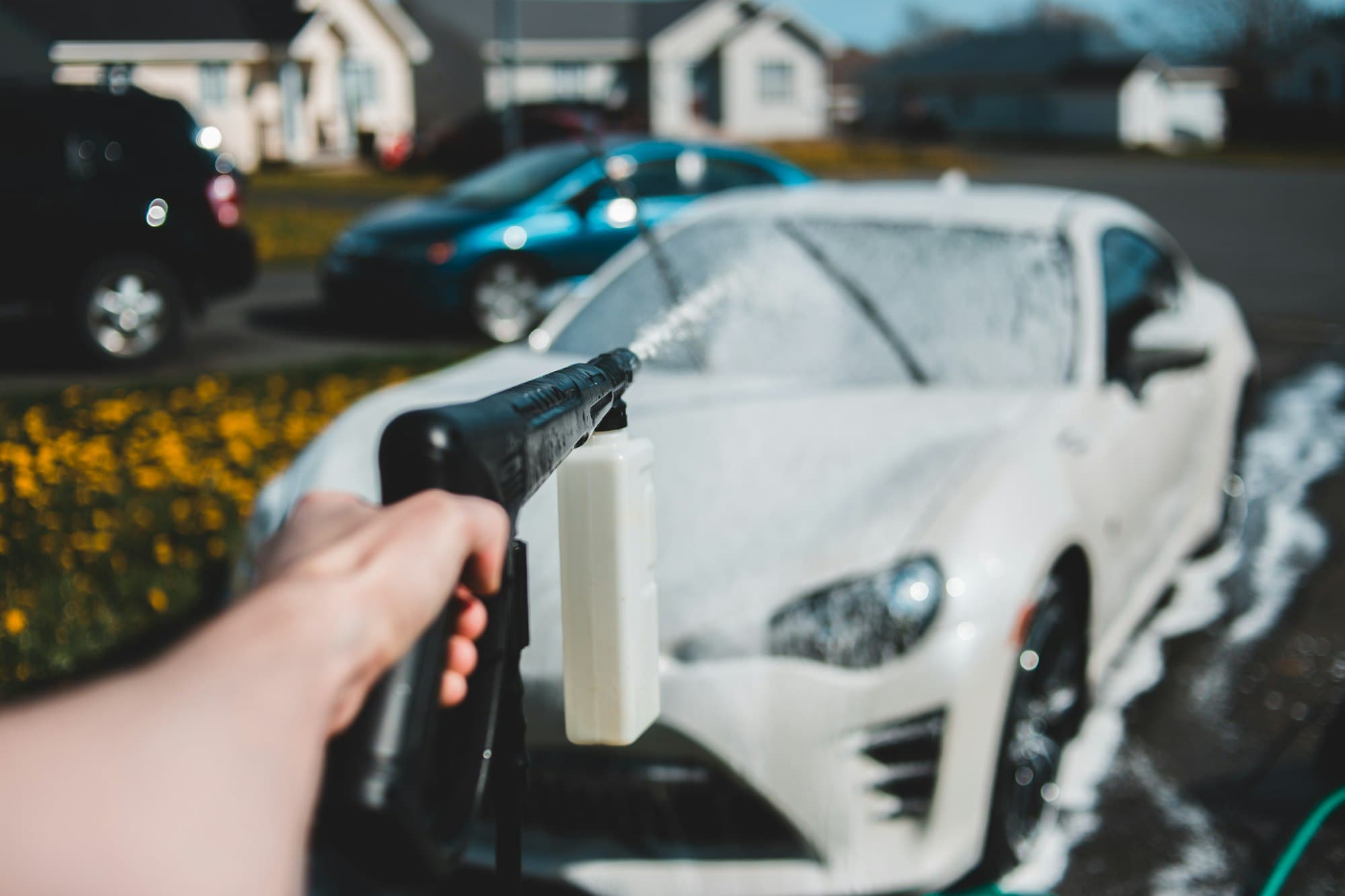 White car being rinsed with a pressure washer