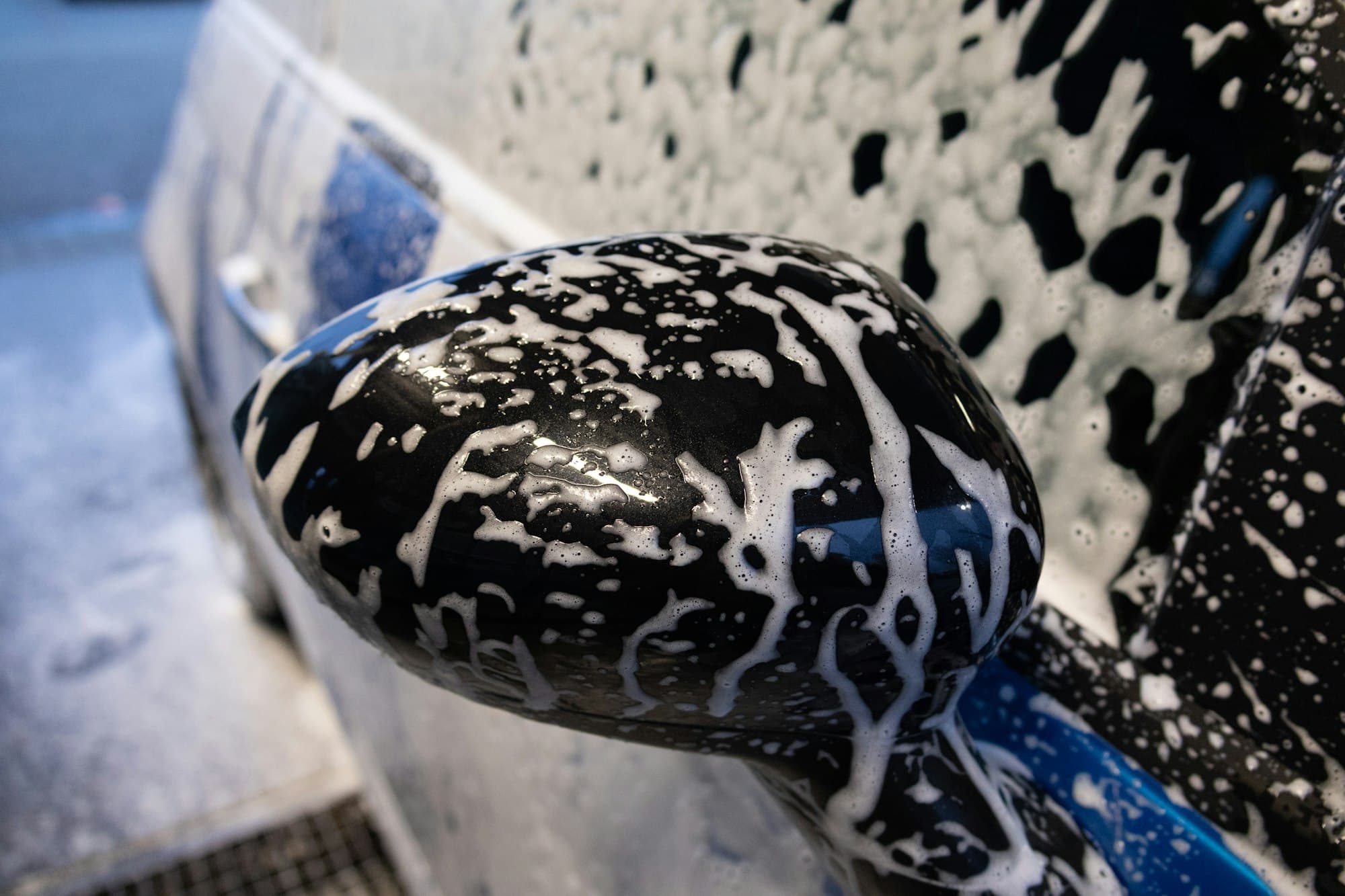 Wash mitt covered in soap suds on a car