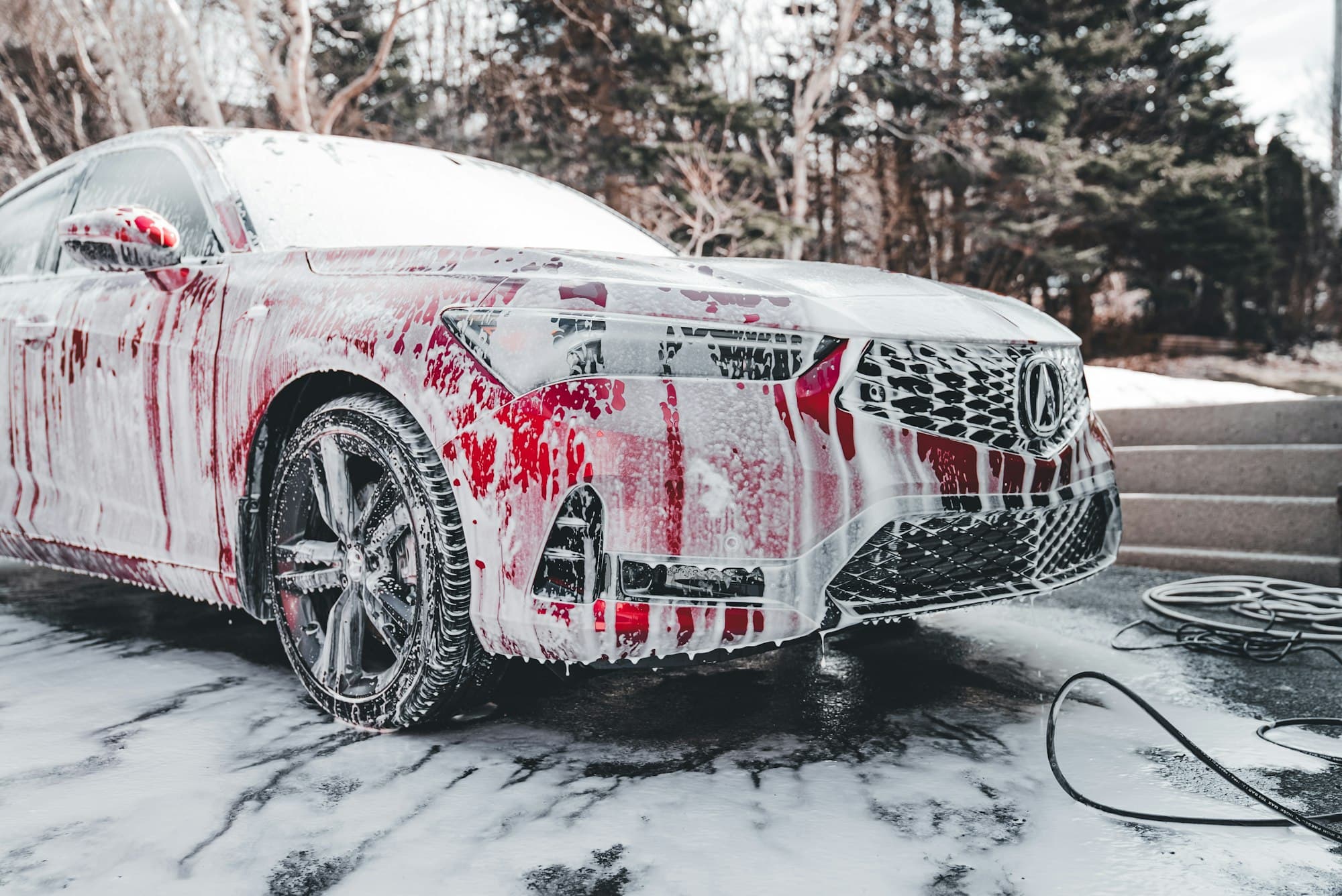 White car covered in foam during a wash
