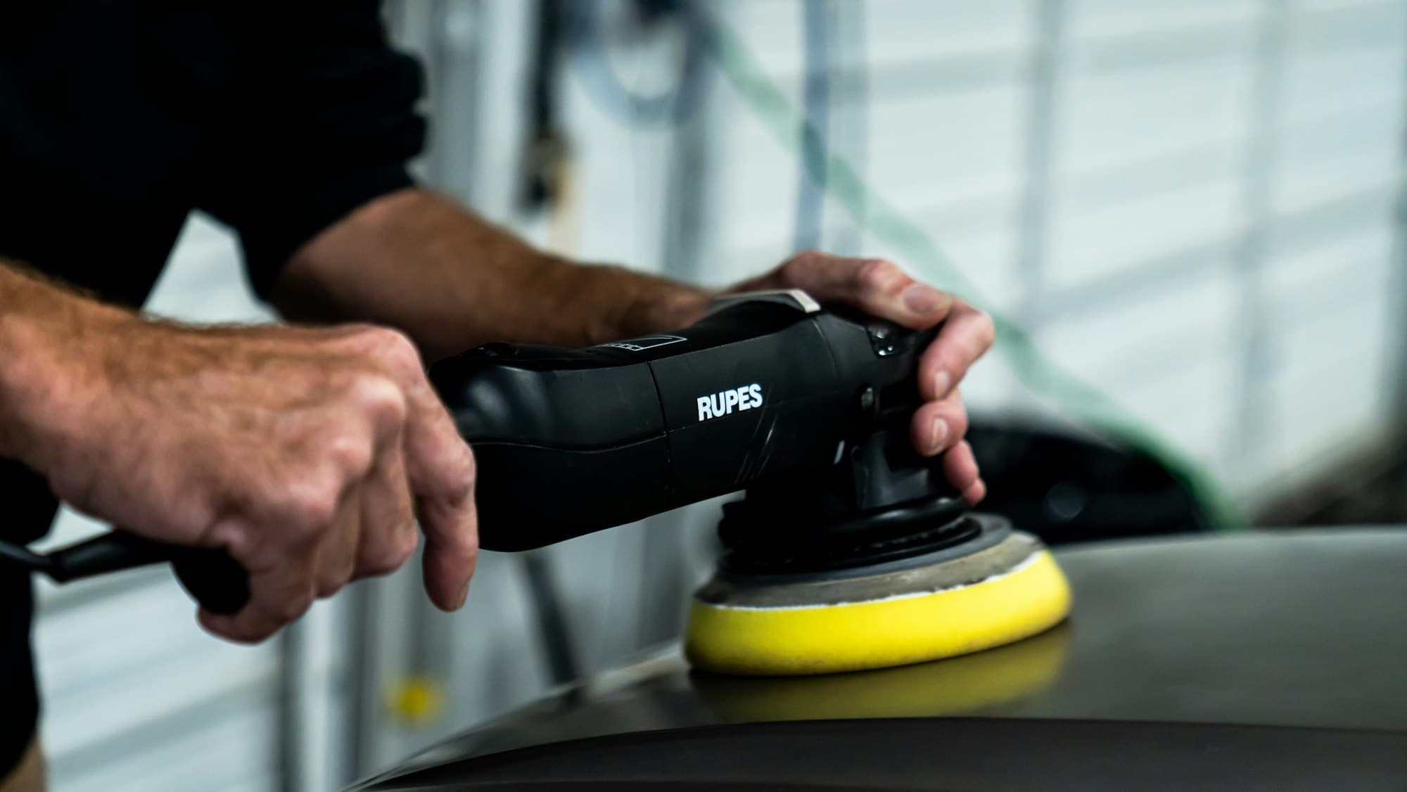 Machine polisher being used on car paintwork