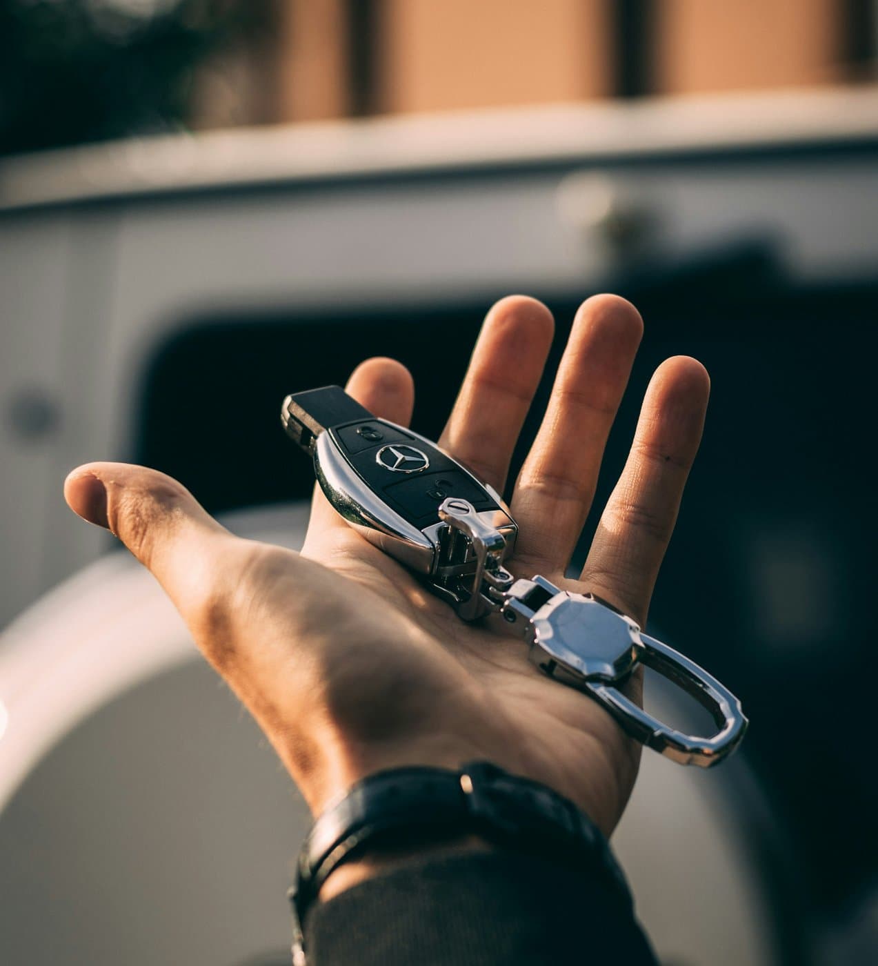 Hand holding a Mercedes smart key
