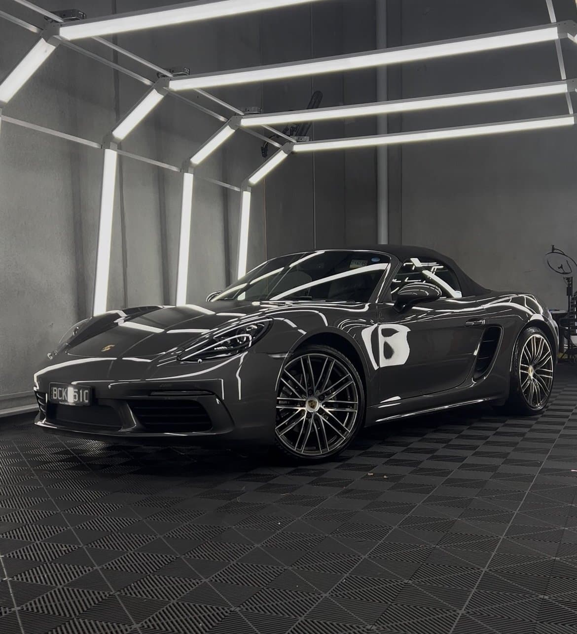 Porsche 718 under detailing inspection lights